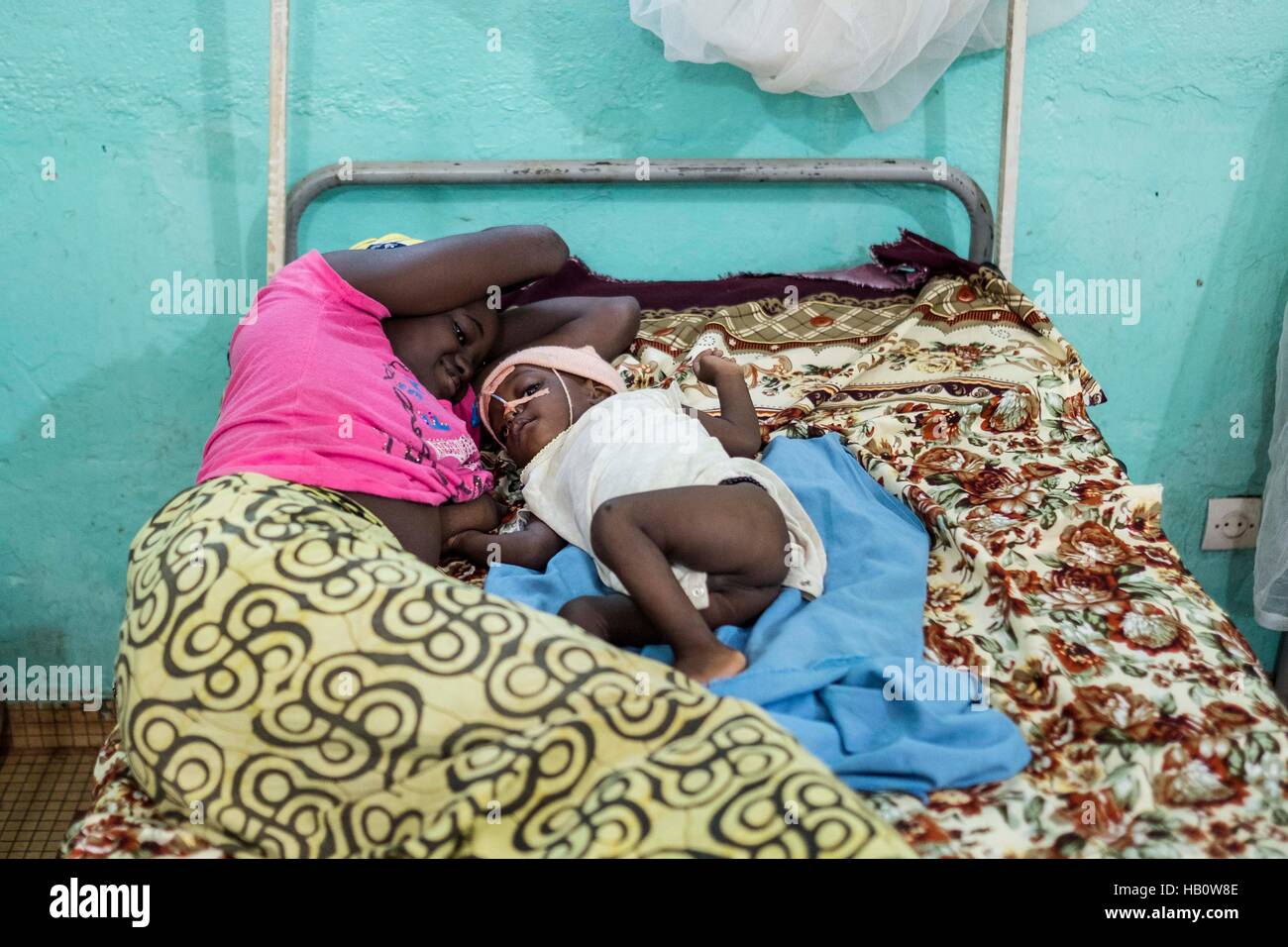 DIOILA - MALI:  A woman lays with her child suffering malnutrition ath the Intensive Nutritional Unit of the Dioila hospital on November 7 2016 in Dio Stock Photo