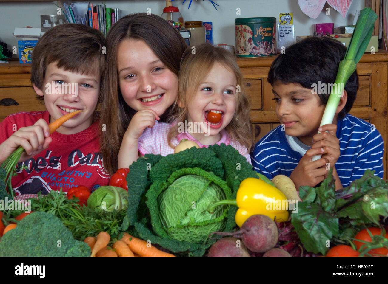 Children (2 boys and 2 girls) with a selection of healthy raw vegetables. a UK Stock Photo