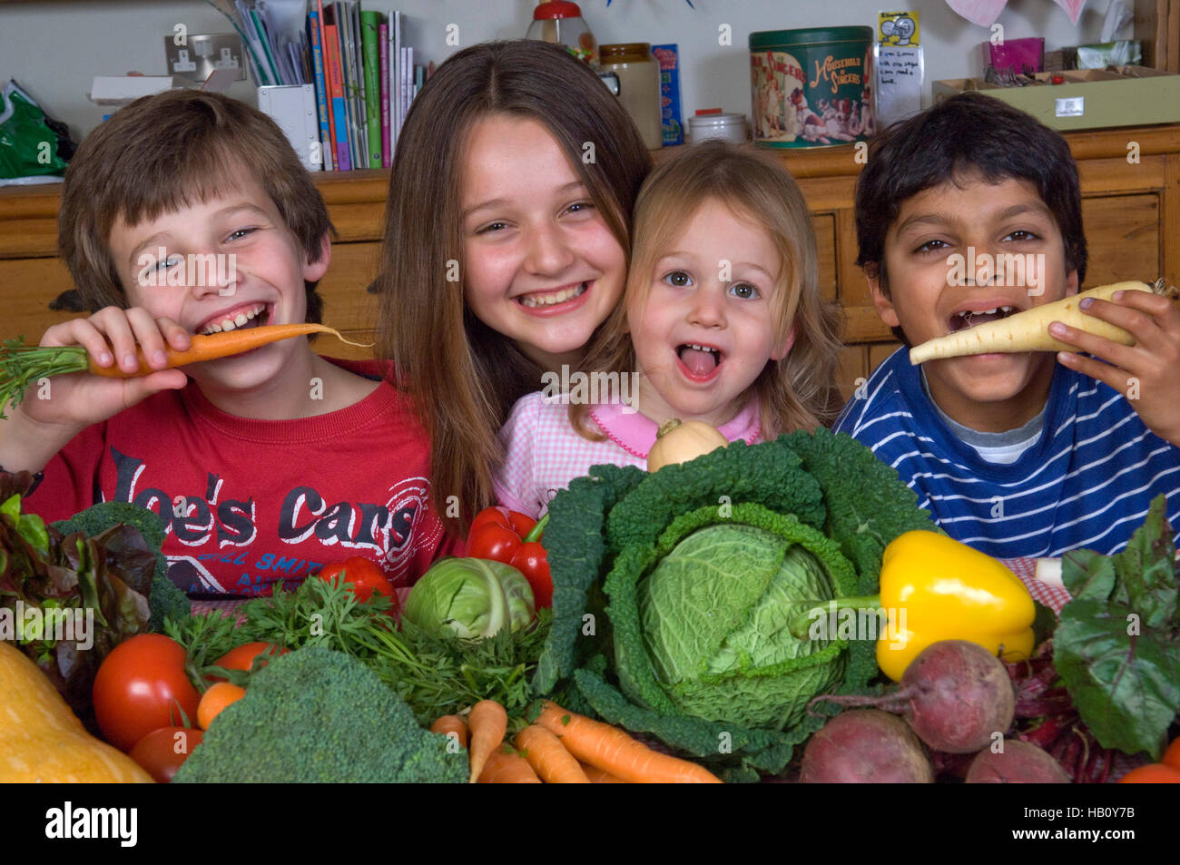 Children (2 boys and 2 girls) with a selection of healthy raw vegetables. a UK Stock Photo
