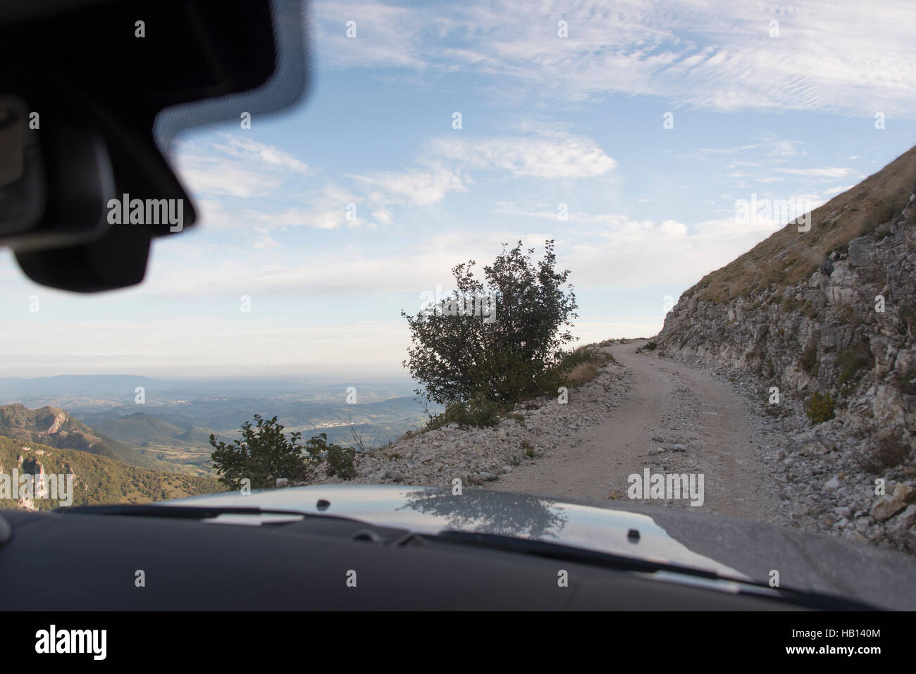 View through the front windscreen of a Land Rover Discovery as it heads up a steep mountain road Stock Photo