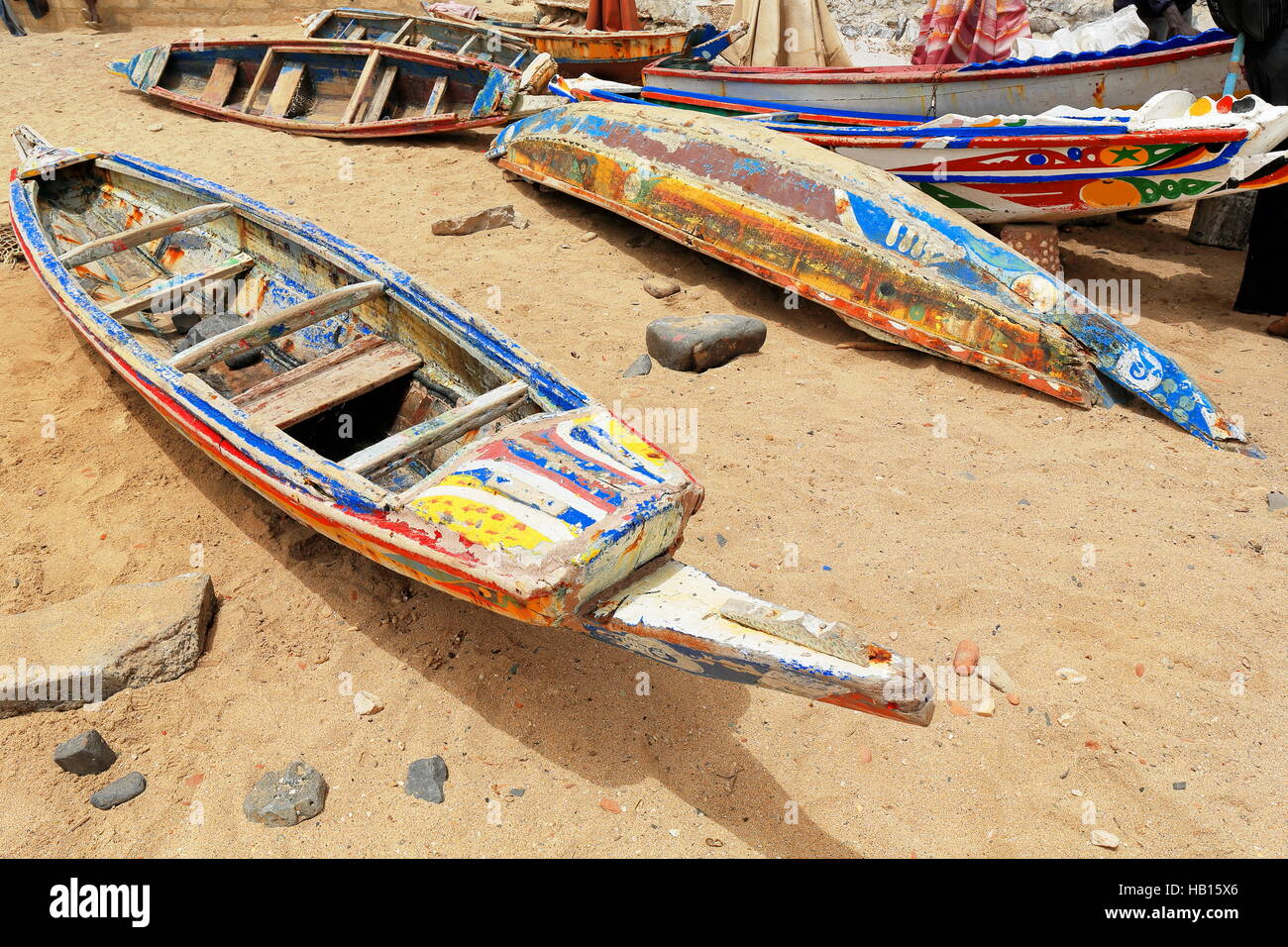 Old wooden colorist fishing boats under the midday sun-seemingly out of order stranded on the sand of the beach inside the harbor of Goree island Stock Photo
