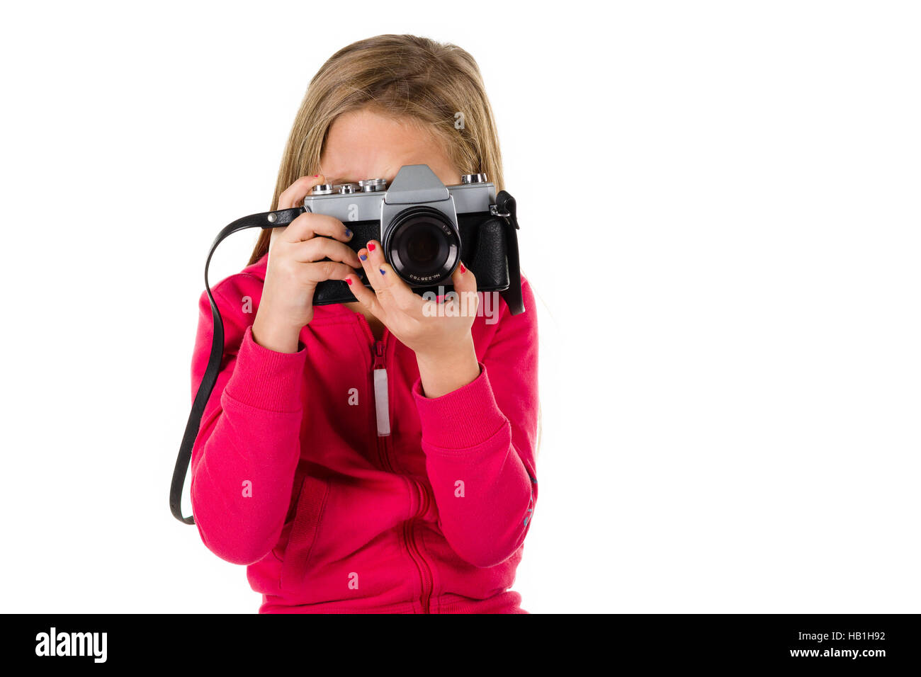 Young girl looking through the viewfinder of  a vintage SLR camera isolated on a white background Stock Photo