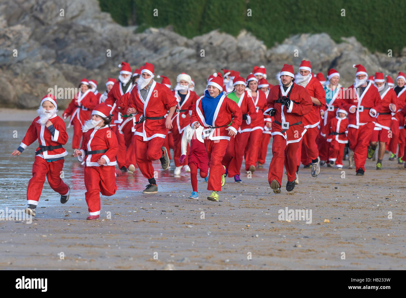 Newquay, UK. 04th Dec, 2016. Fistral Beach; Newquay, Cornwall. 4th December, 2016. Hundreds of Santas turned out for a fund-raising fun run across a chilly Fistral Beach in the annual Santa Run in Newquay, Cornwall. Photographer Credit:  Gordon Scammell/Alamy Live News Stock Photo