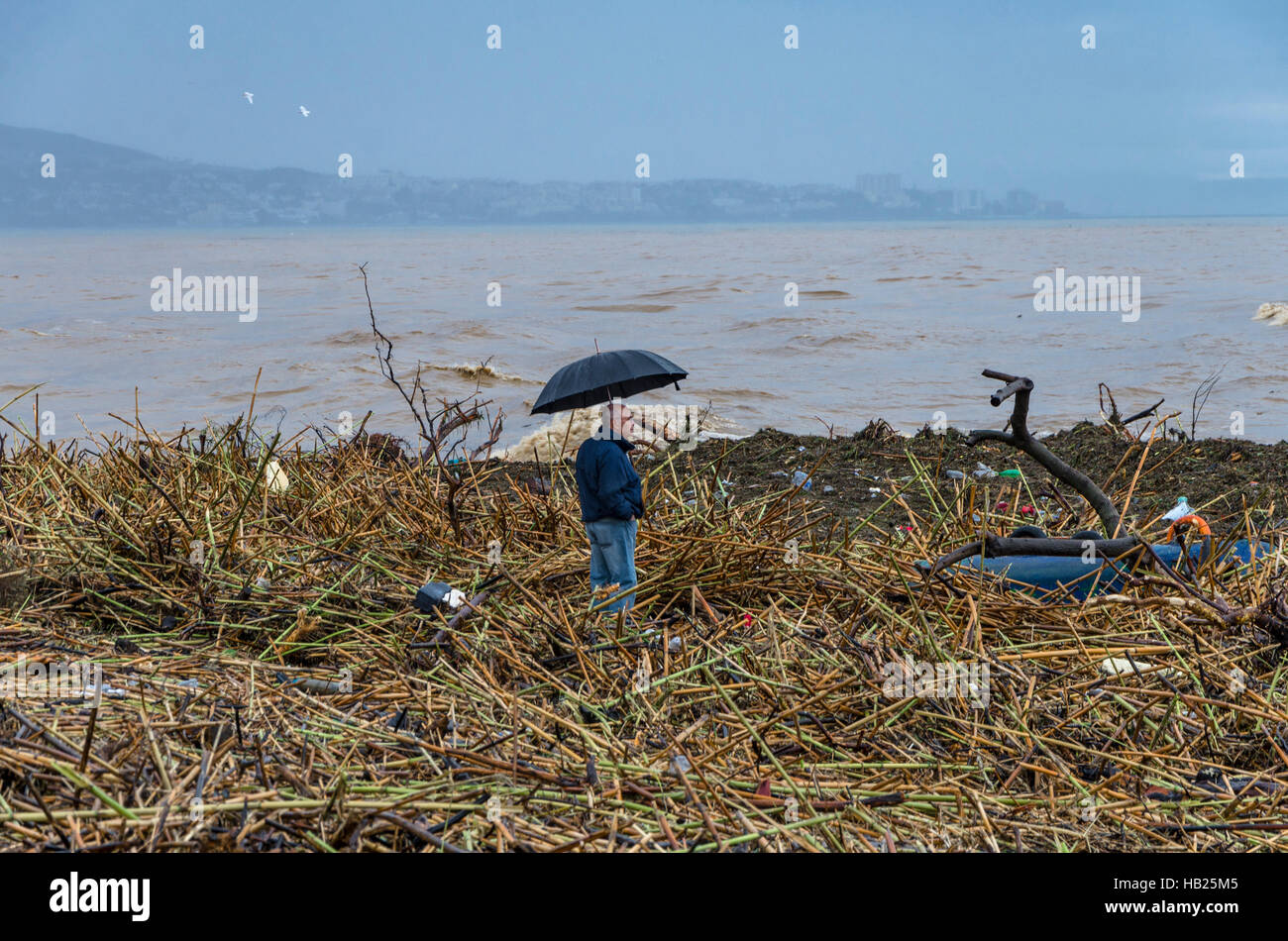 Fuengirola, Andalusia, Spain. 4th december, Man standing in between debris at Fuengirola river becoming Flash flood leaving debris behind at river mouth. 2016. Credit:  Perry van Munster/ Alamy Live News Stock Photo