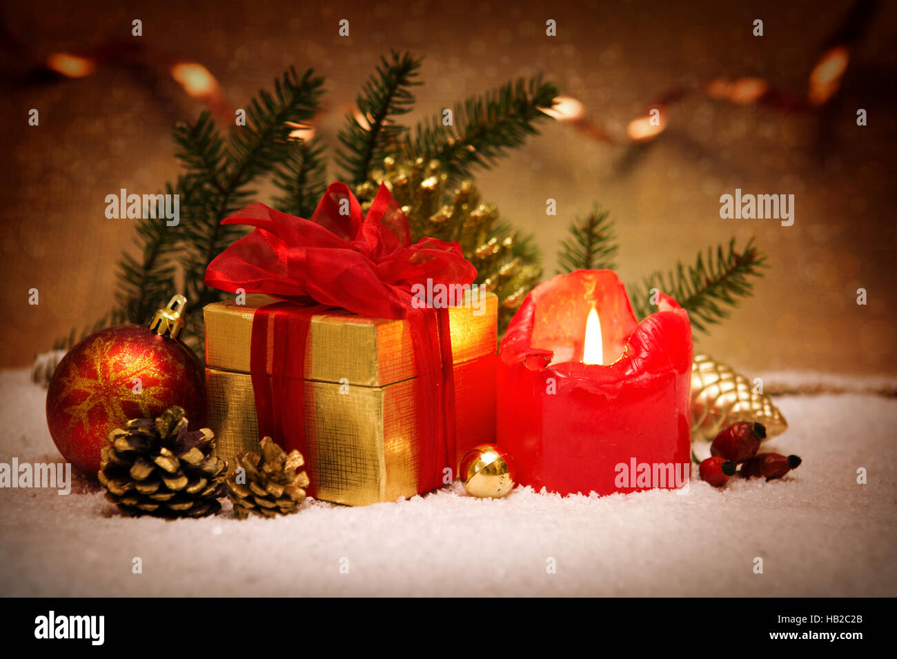 Red Advent candle and Christmas gift. Stock Photo