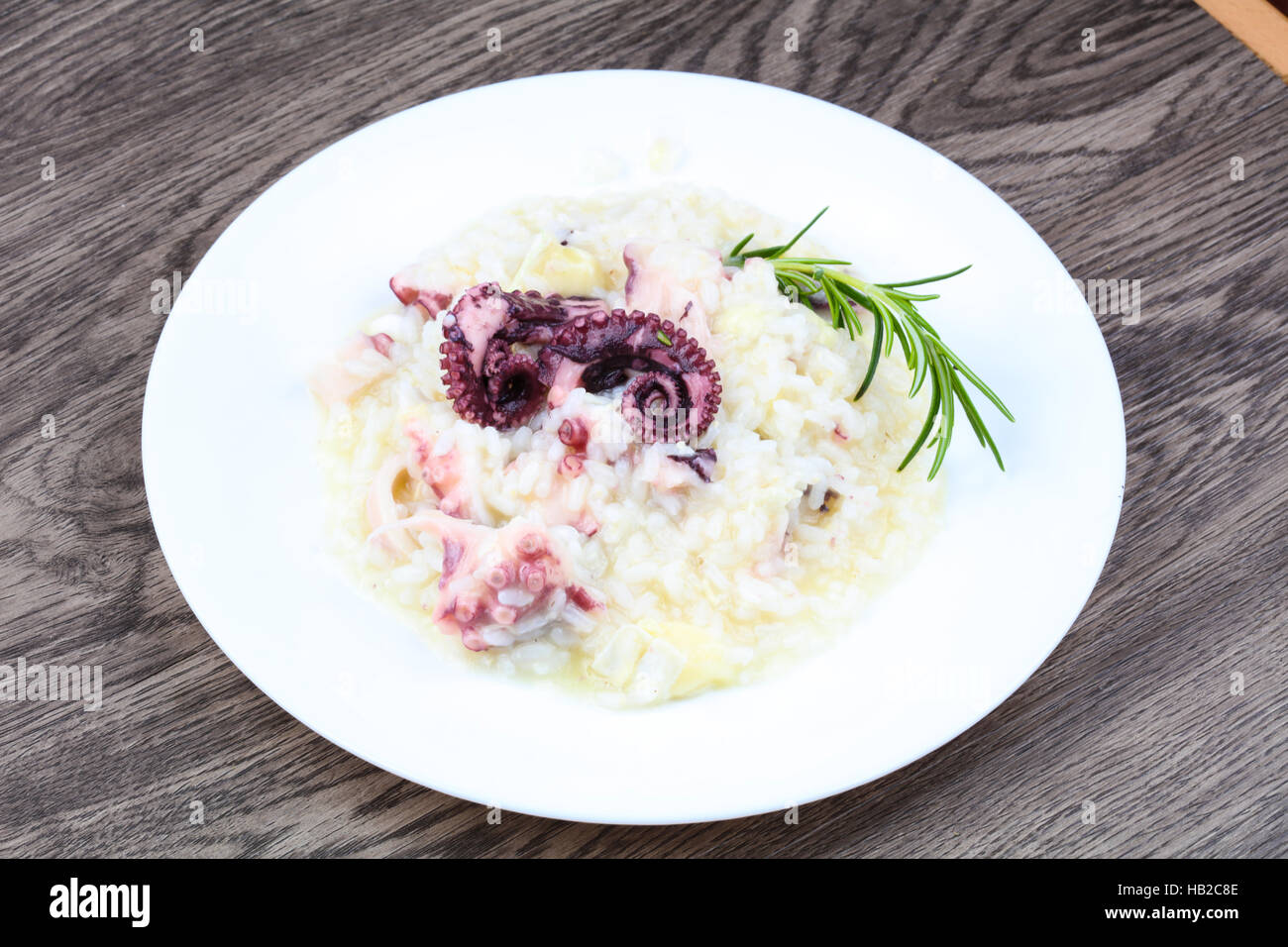 Risotto with octopus served green rosemary Stock Photo - Alamy
