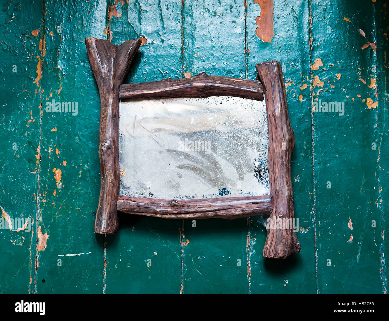 Old dusty mirror with cobwebs and scratches cracks on the wooden floor