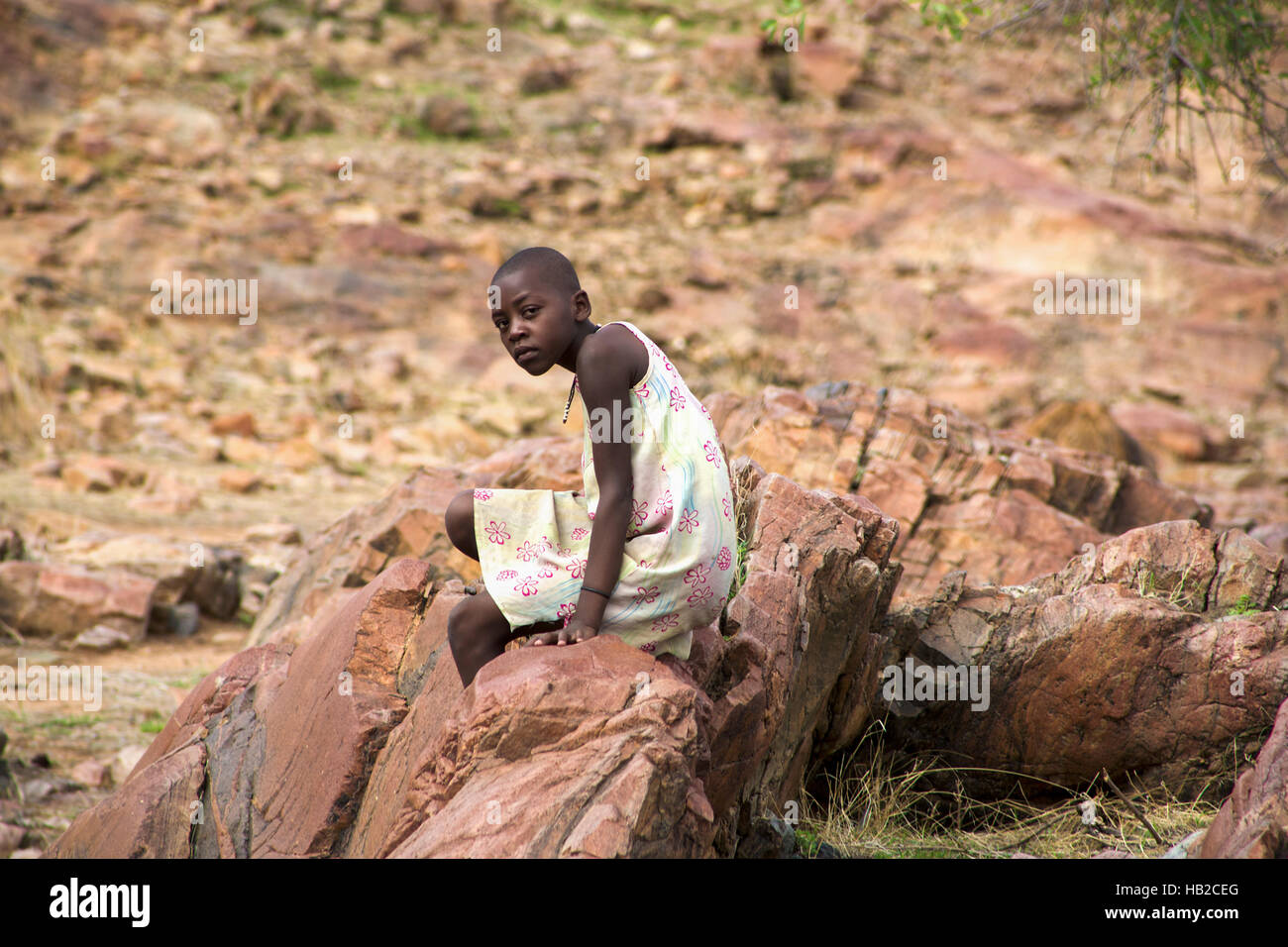 Young Himba posing in front of the camera at Epupa Falls in Namibia Stock Photo