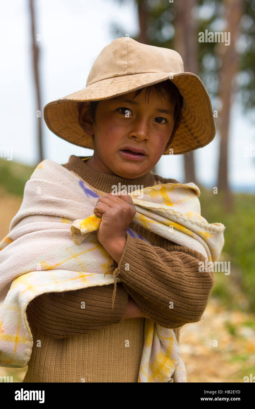MOON ISLAND, BOLIVIA, JANUARY 13: Portrait of young small Bolivian boy standing and looking at the camera on Isla del Sol (Moon Island), Copacabana. Stock Photo