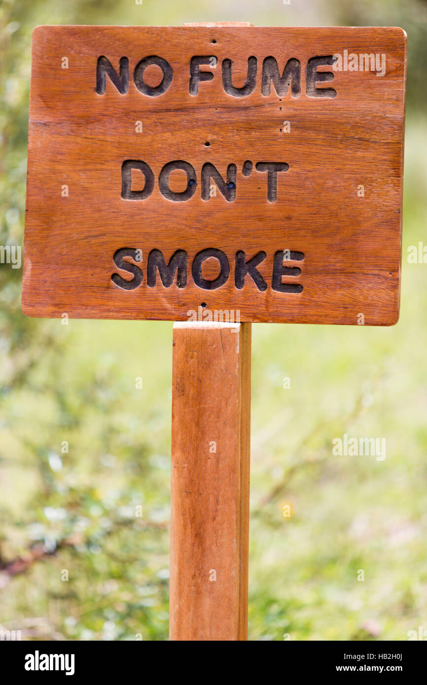 Closeup on rustic old wooden sign with No fume (Don't smoke) written in