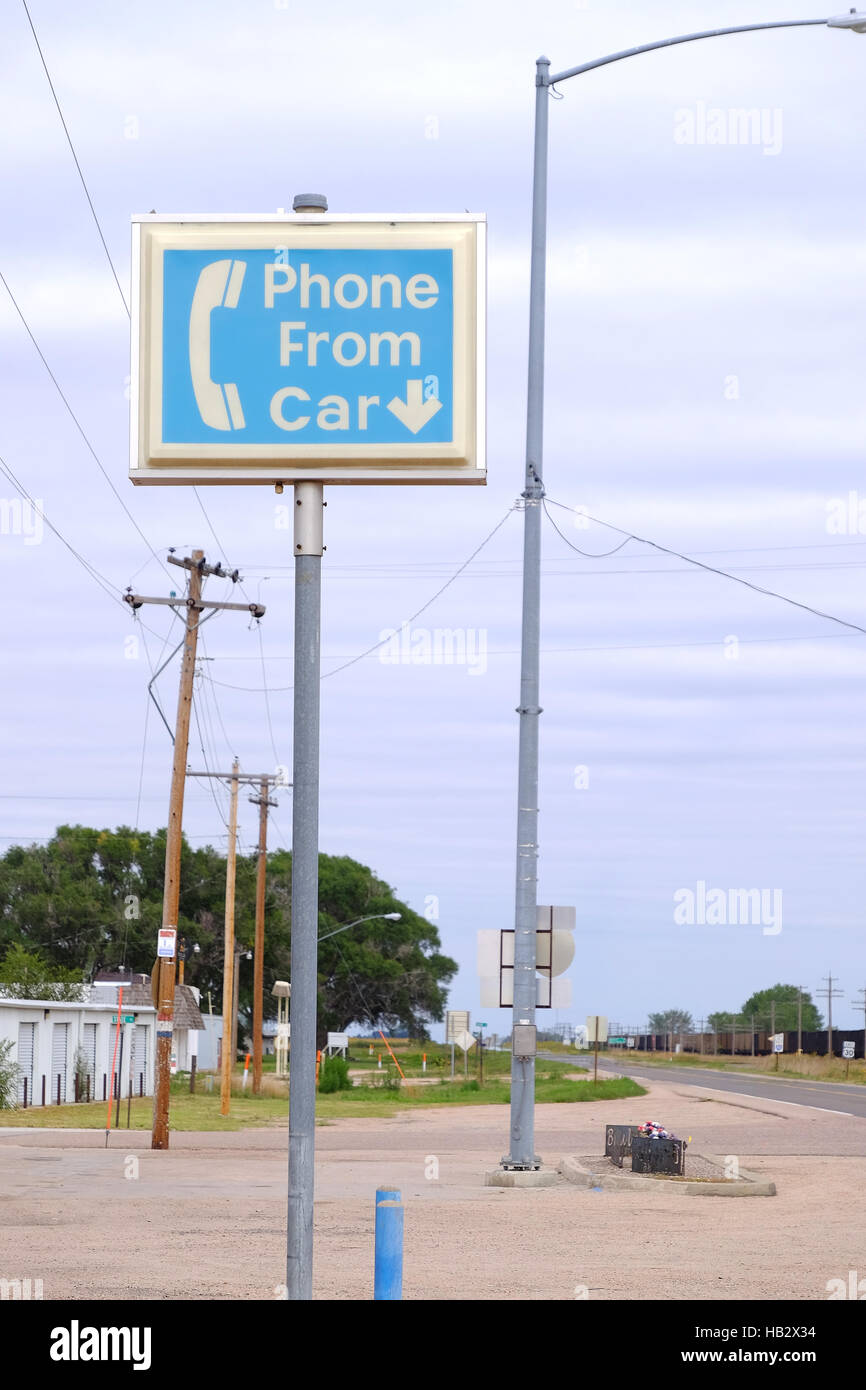An old phone booth sign still stands on the side of the highway in rural Nebraska even though the booth is long gone. Stock Photo