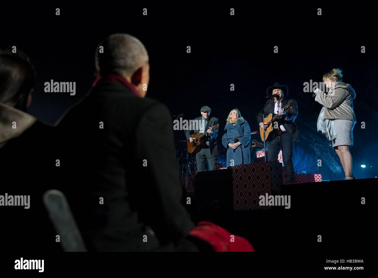 U.S President Barack Obama watches James Taylor, Kim Taylor, Garth Brooks and Trisha Yearwood perform during the national Christmas tree lighting ceremony on the Ellipse December 1, 2016 in Washington, DC. Stock Photo