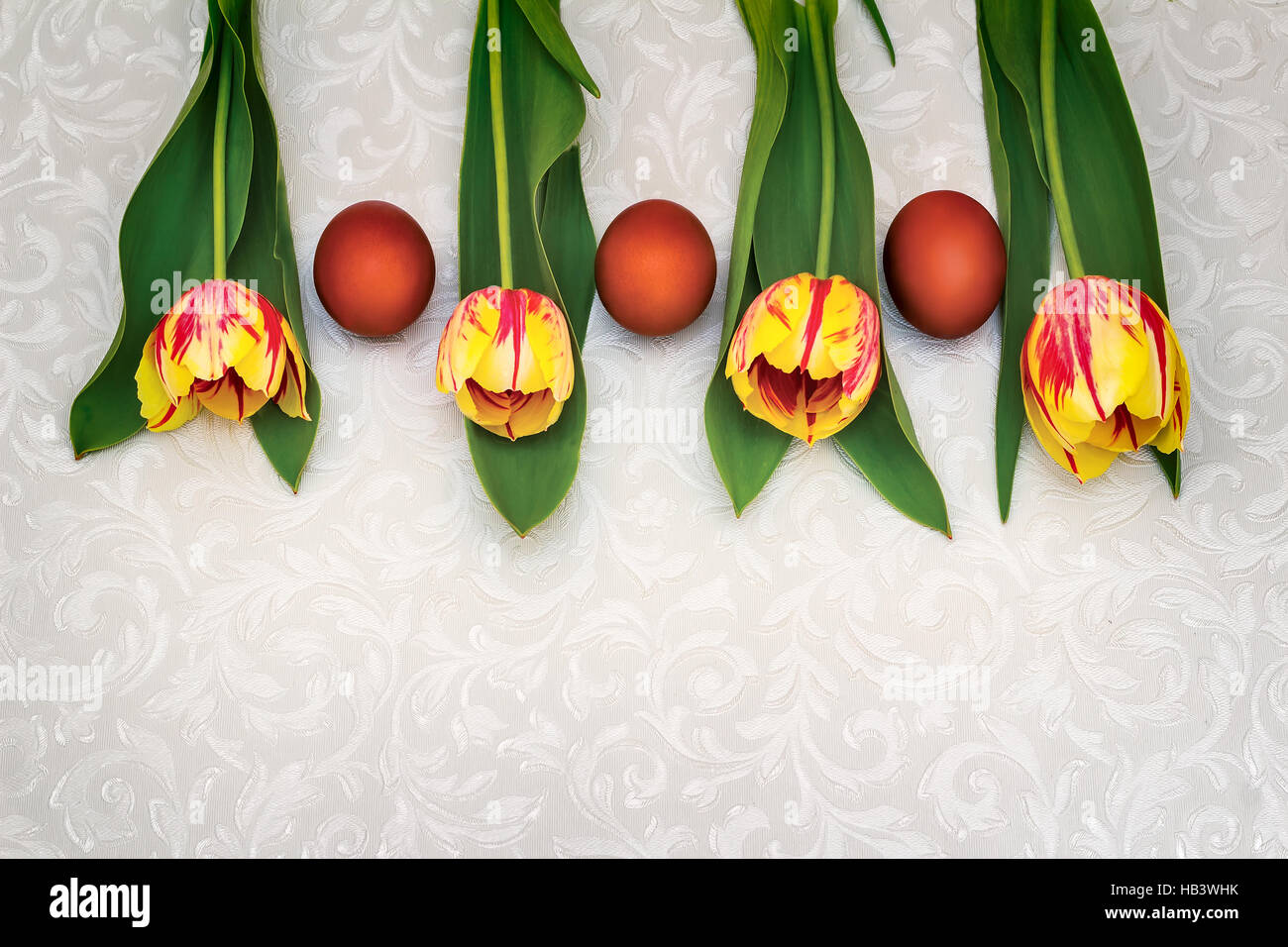 Three Easter eggs and tulips Stock Photo - Alamy