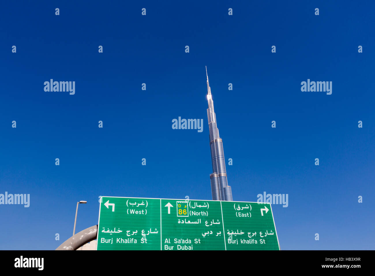 Burj Khalifa with directional sign and clear blue sky in Dubai Stock Photo