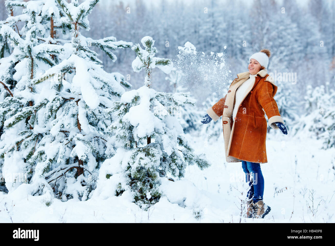 Young pregnant woman wearing warm clothes having fun on beautiful winter snowy day Stock Photo