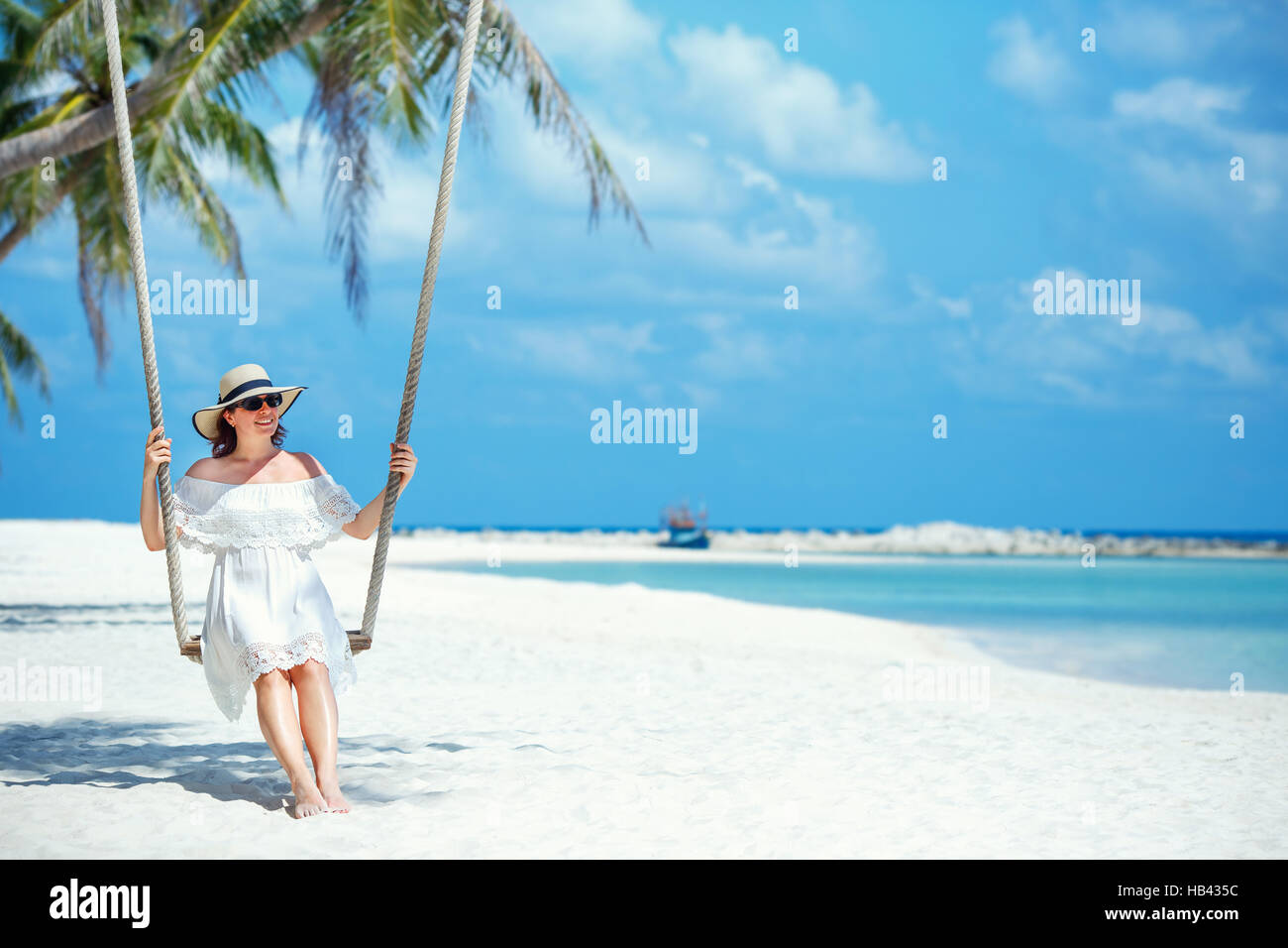 Beautiful woman swinging on a Tropical beach, Koh Phangan island. Thailand. Stock Photo
