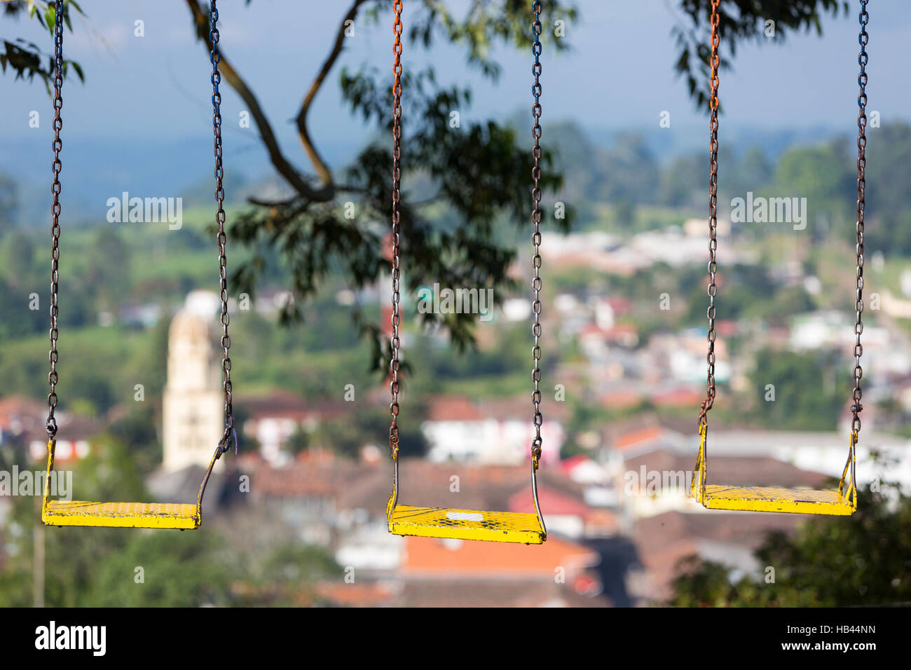 Empty swing in a children play area with Salento view in the background, Colombia Stock Photo