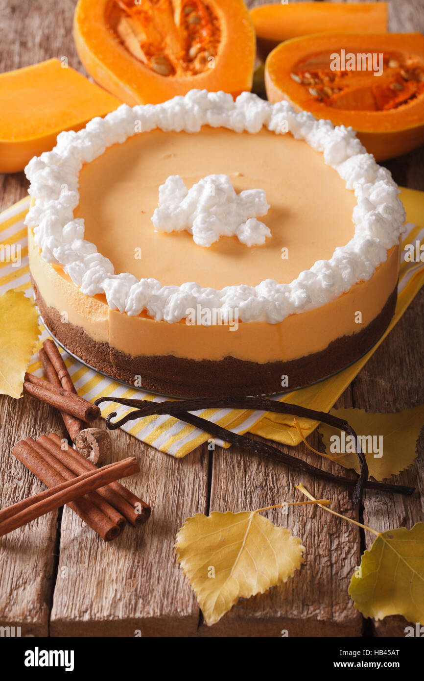 pumpkin pie with cinnamon, vanilla and whipped cream close-up on the table. vertical Stock Photo