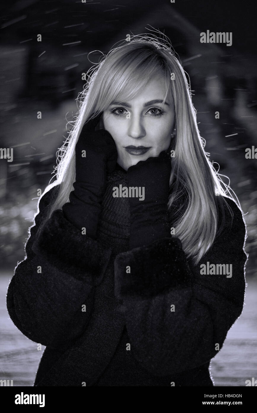 Portrait of woman at snowing nigh Stock Photo