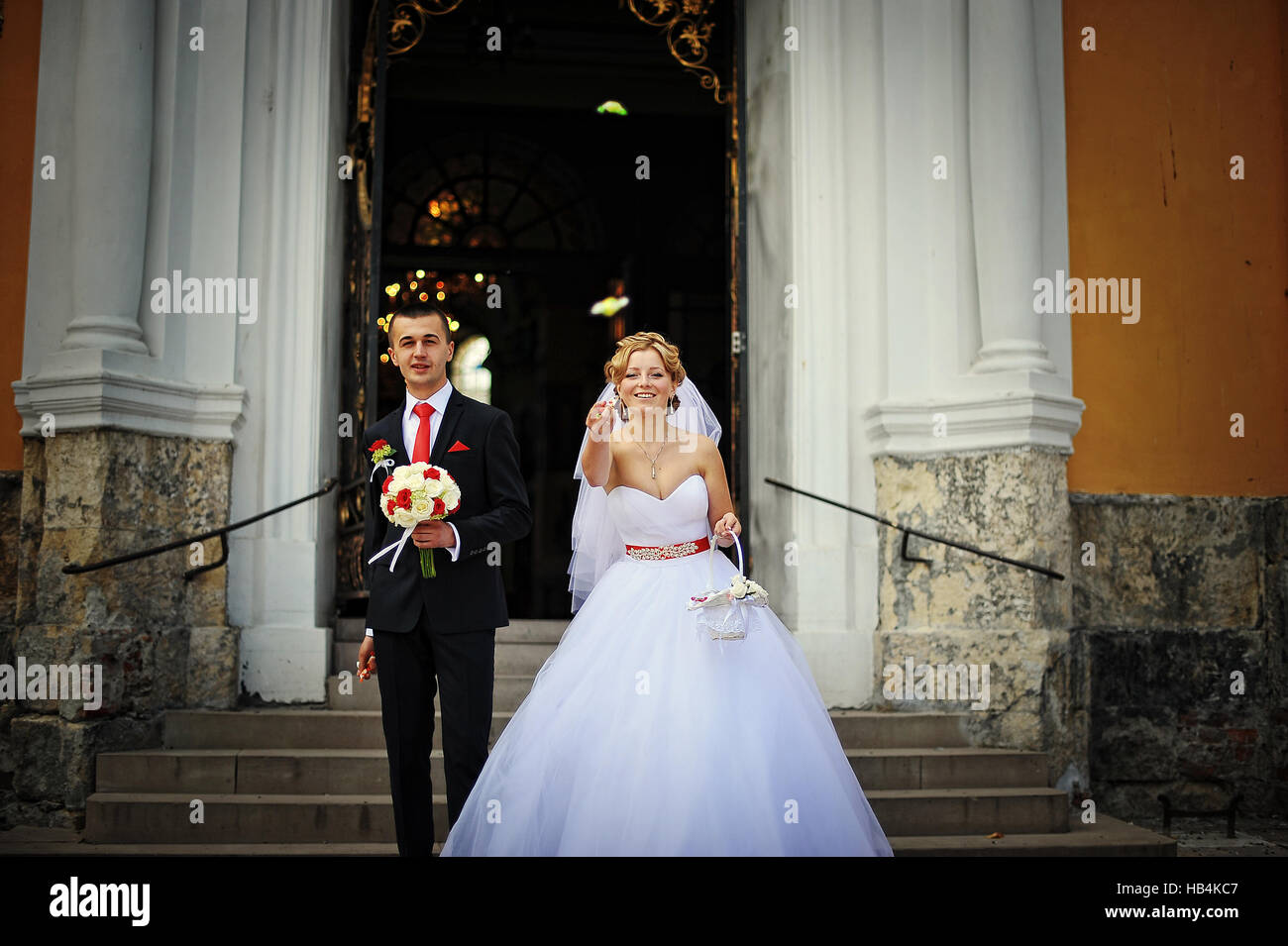 Newlyweds exit the church to throw candy Stock Photo