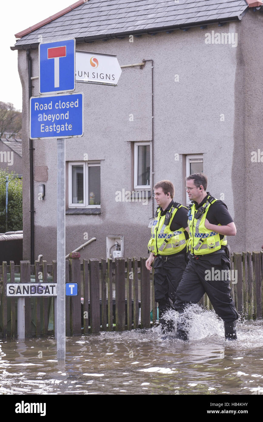 Cumbria Police officers walk through flood water on Sandgate in Kendal