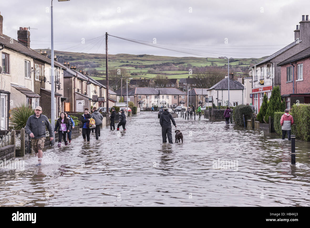 Residents negotiate a flooded road in Sandylands, Kendal in Cumbria on