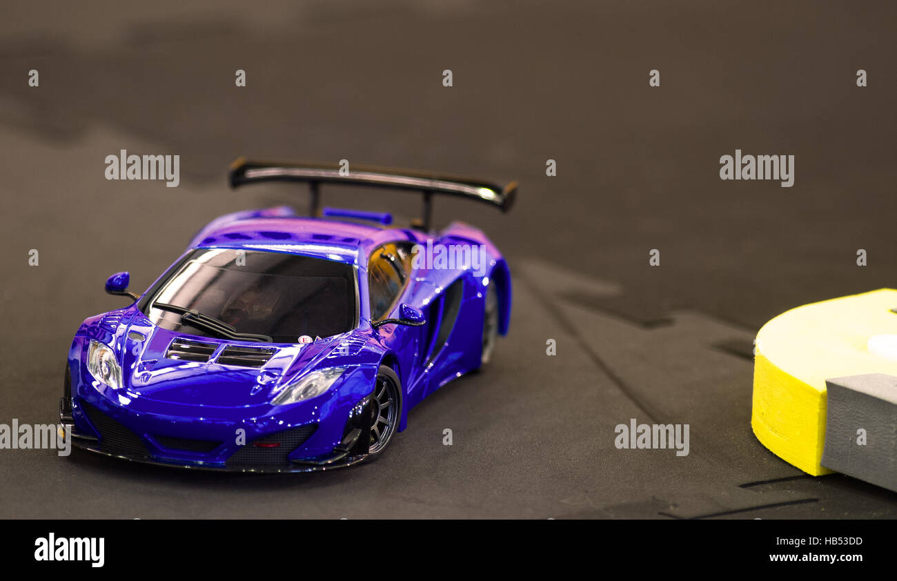 Shiny miniature Radio controlled RC blue race car (mini z type) turning in rubber track Stock