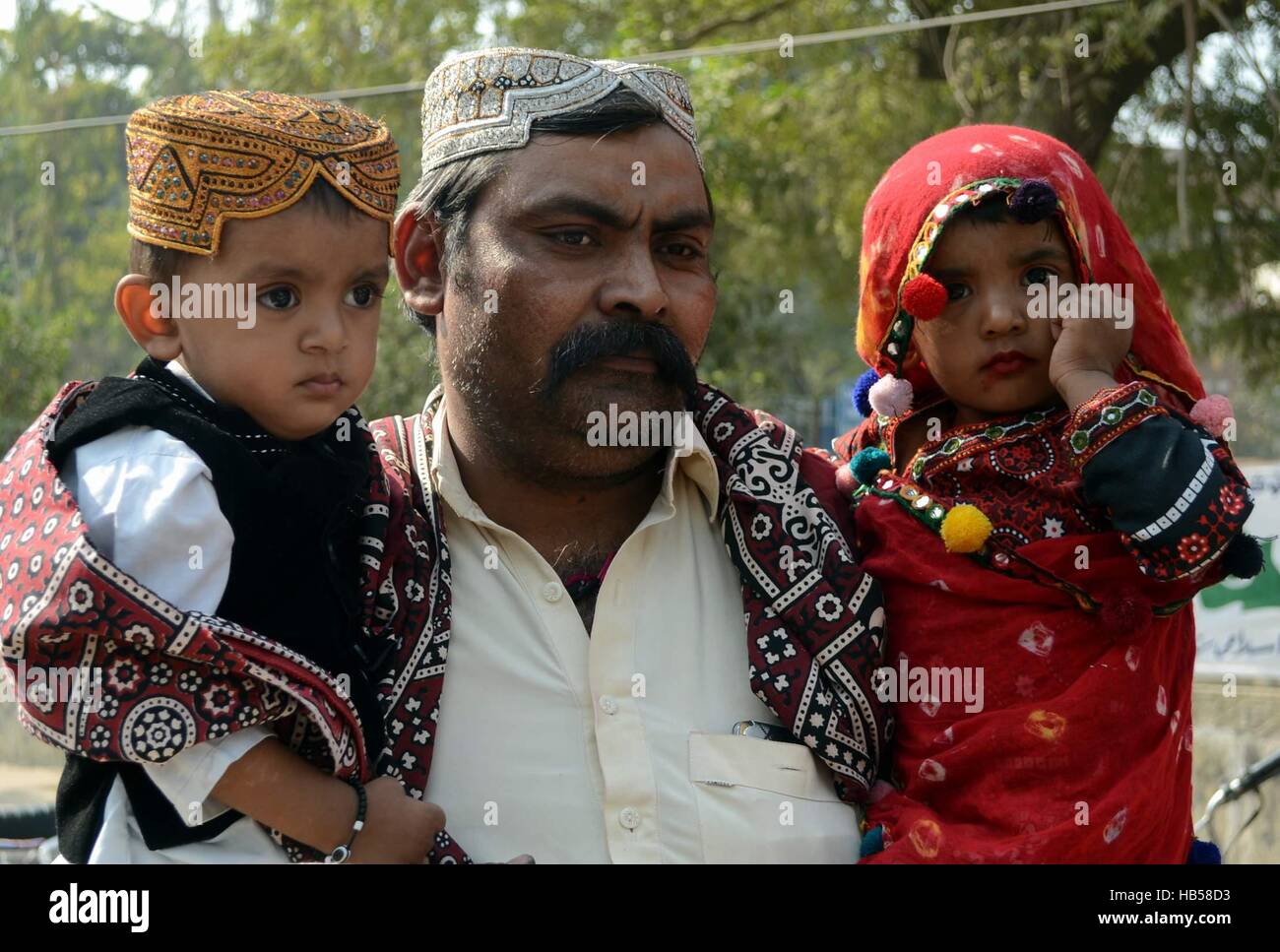 Hyderabad, Pakistan. 04th Dec, 2016. A man with there children in a sindhi  tradional dress take part in the celebration of Sindhi culture day at  Hyderabad Credit: Janali Laghari/Pacific Press/Alamy Live News