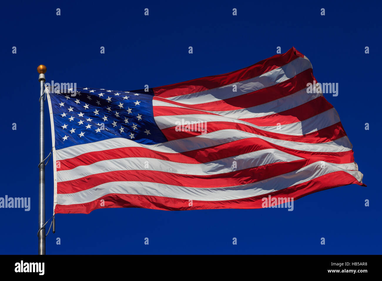 American flag waving in clear blue sky Stock Photo - Alamy