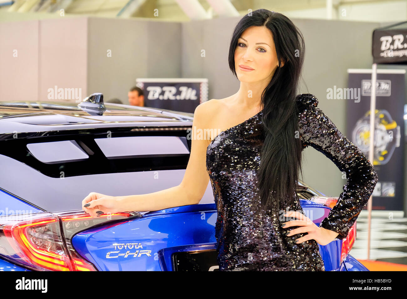 Bologna, Italy, Dec 03 2016 - a black haired elegant model posing leaning to a Toyota C-HR car during the Motor Show 2016 in Bologna Stock Photo