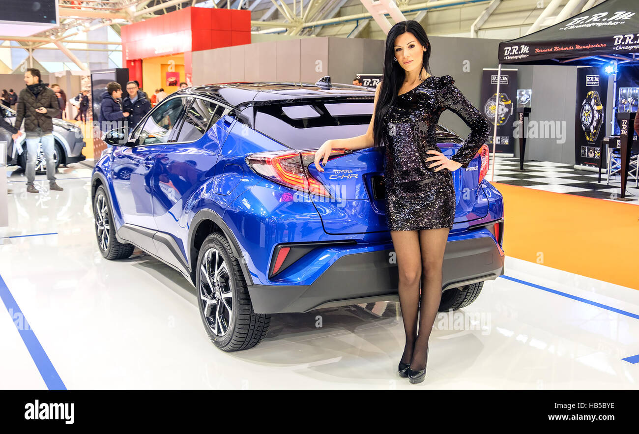 Bologna, Italy, Dec 03 2016 - a black haired elegant model posing leaning to a Toyota C-HR car during the Motor Show 2016 in Bologna Stock Photo