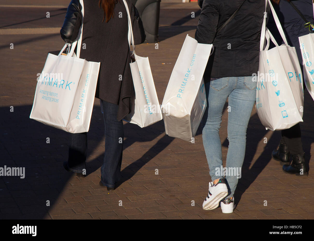 Shoppers with white canvas Primark reusable bags of store fashioin ...