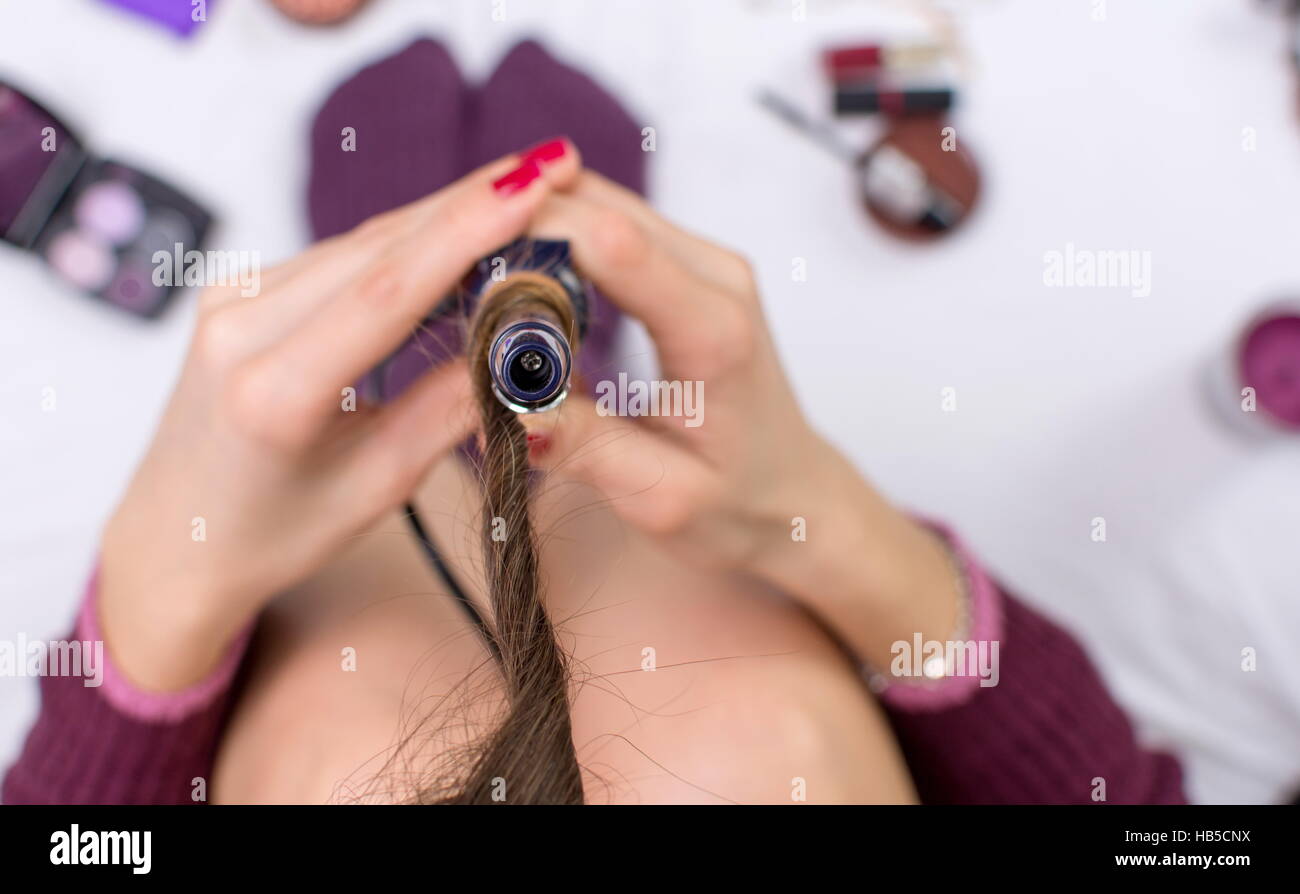 point of view of a woman using curling iron Stock Photo