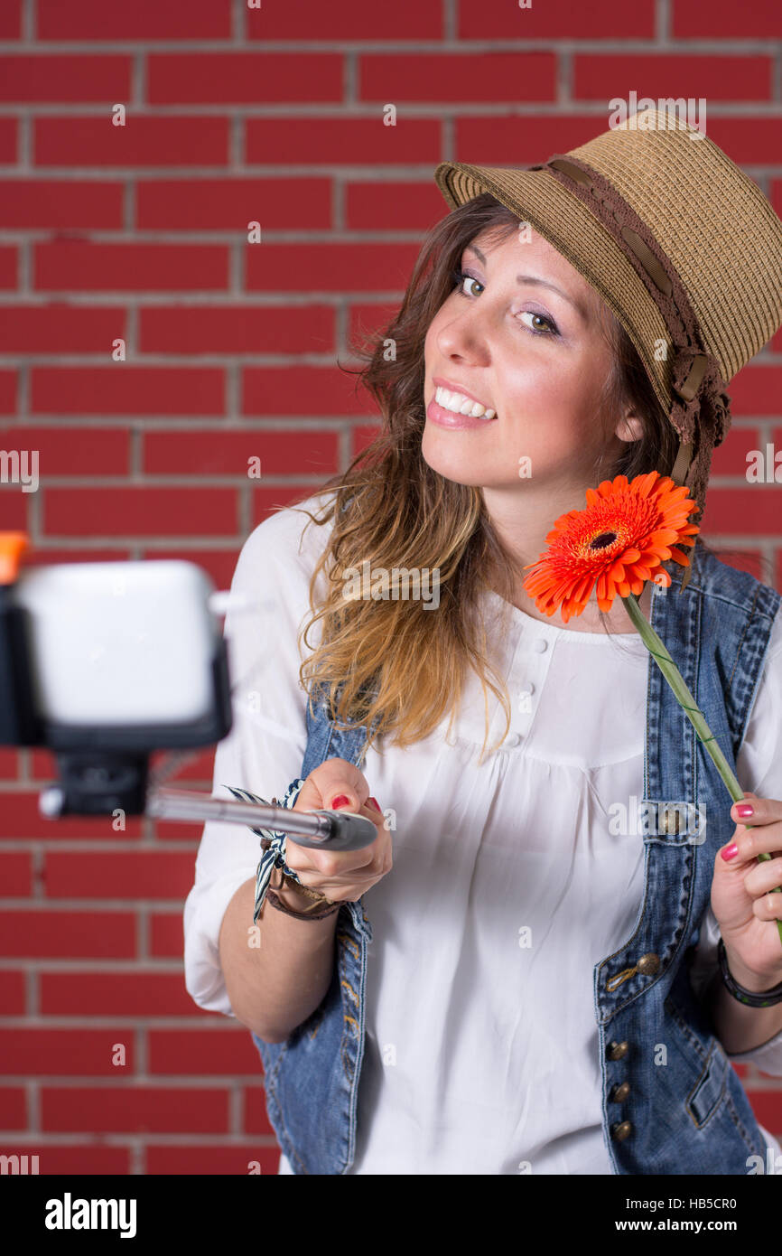 Girl taking selfie in front of brick wall Stock Photo
