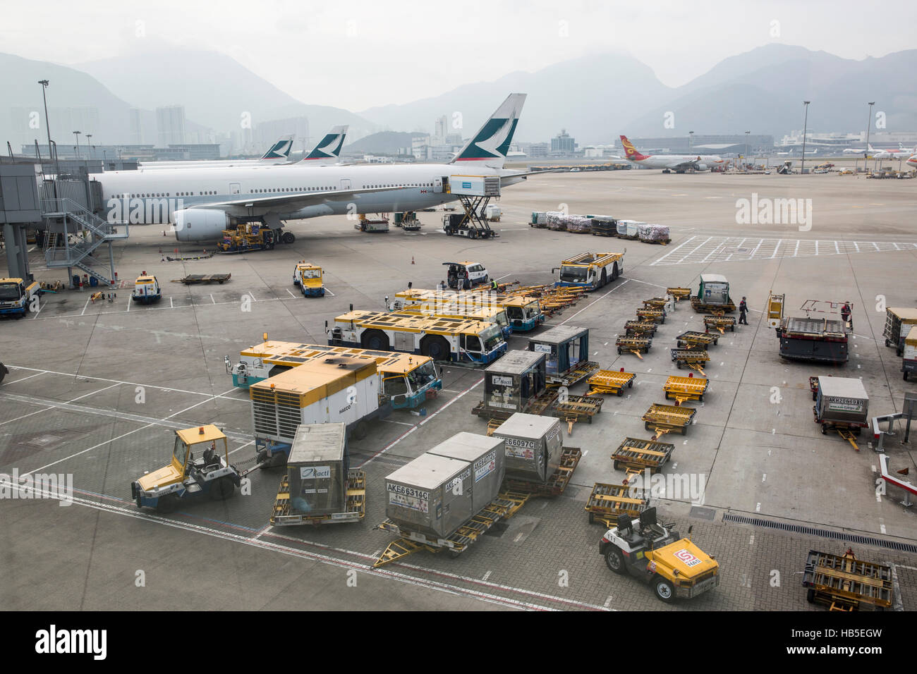 A airplane is being loaded with cargo in preparation for departure at Hongkong International Airport Stock Photo