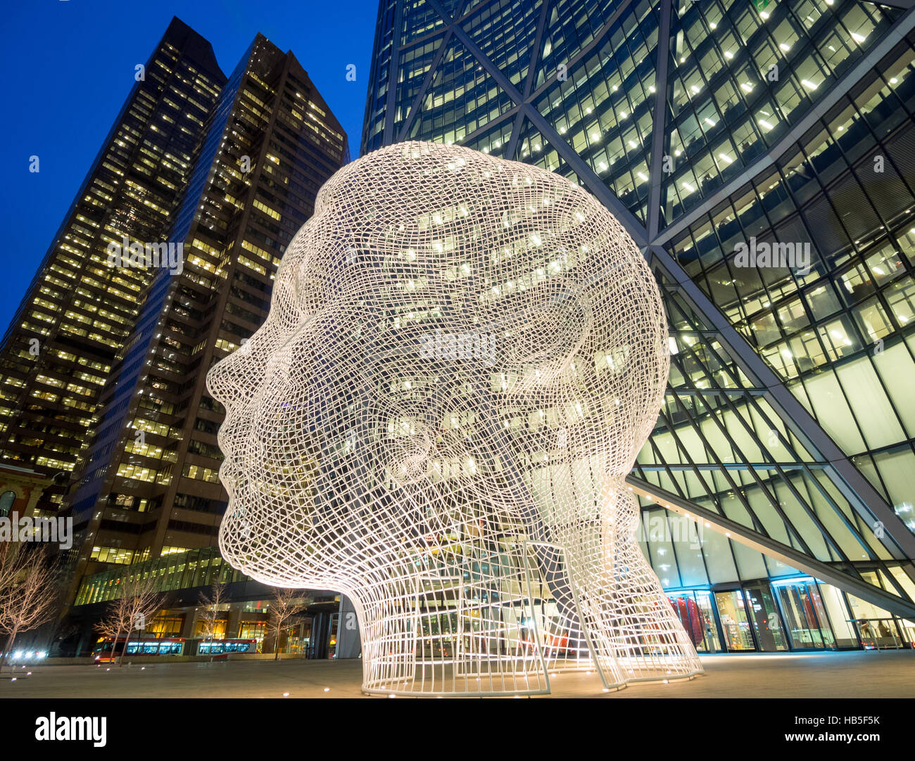 A night, fisheye view of the sculpture Wonderland by Jaume Plensa, in front of The Bow skyscraper in Calgary, Alberta, Canada. Stock Photo