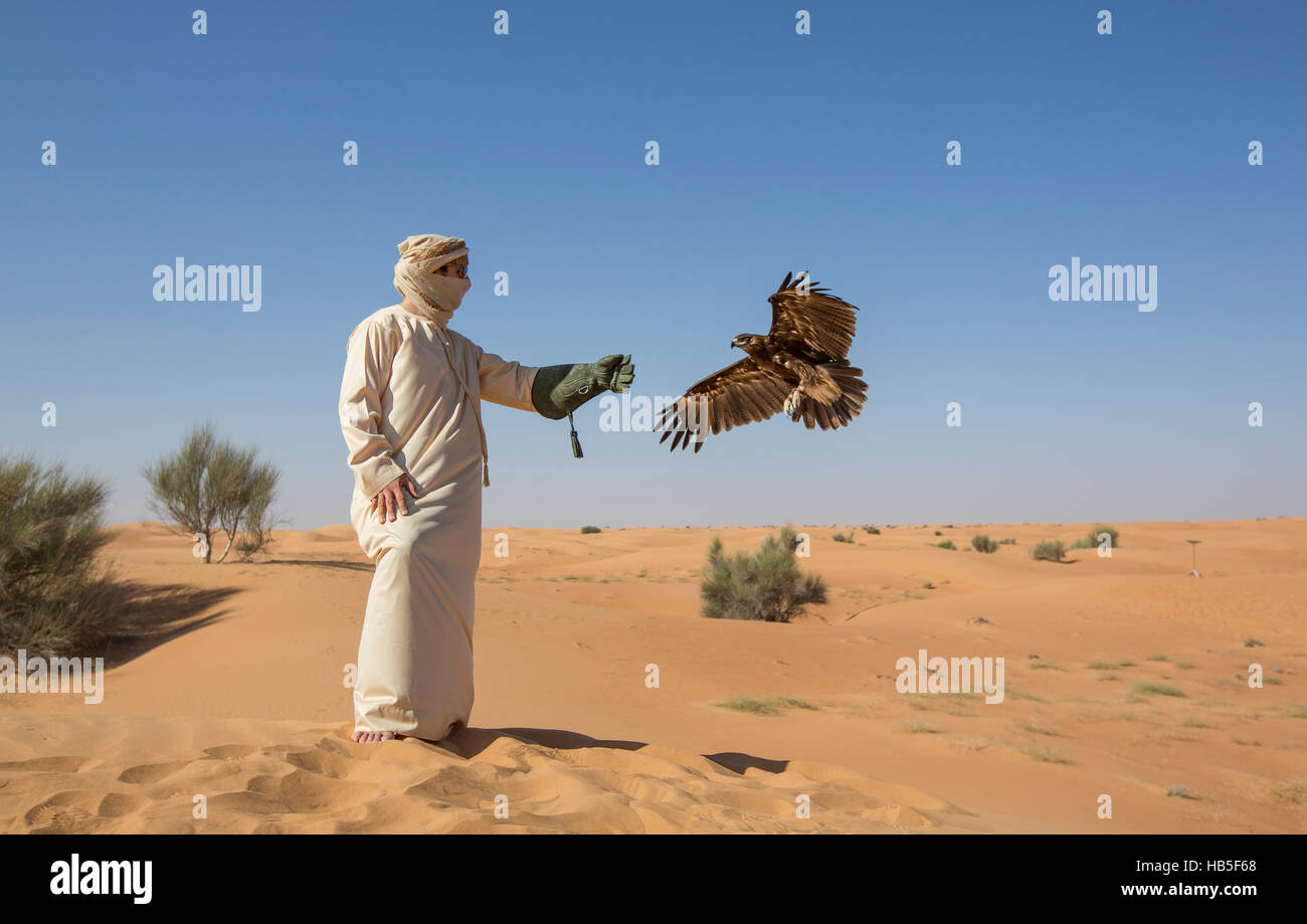 Man in a desert with Greater Spotted eagle (clanga clanga) Stock Photo