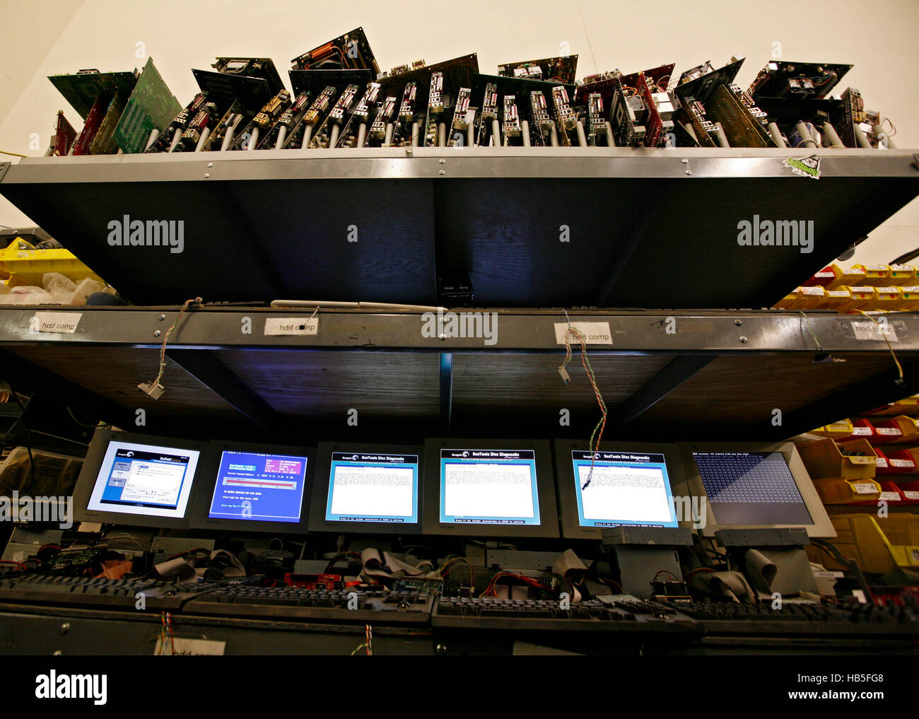 Hard drives and monitors sit on shelves in the back of a Goodwill store