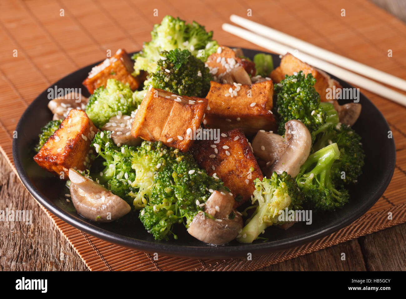 Vegetarian Stir Fry tofu with broccoli, mushrooms and sesame closeup