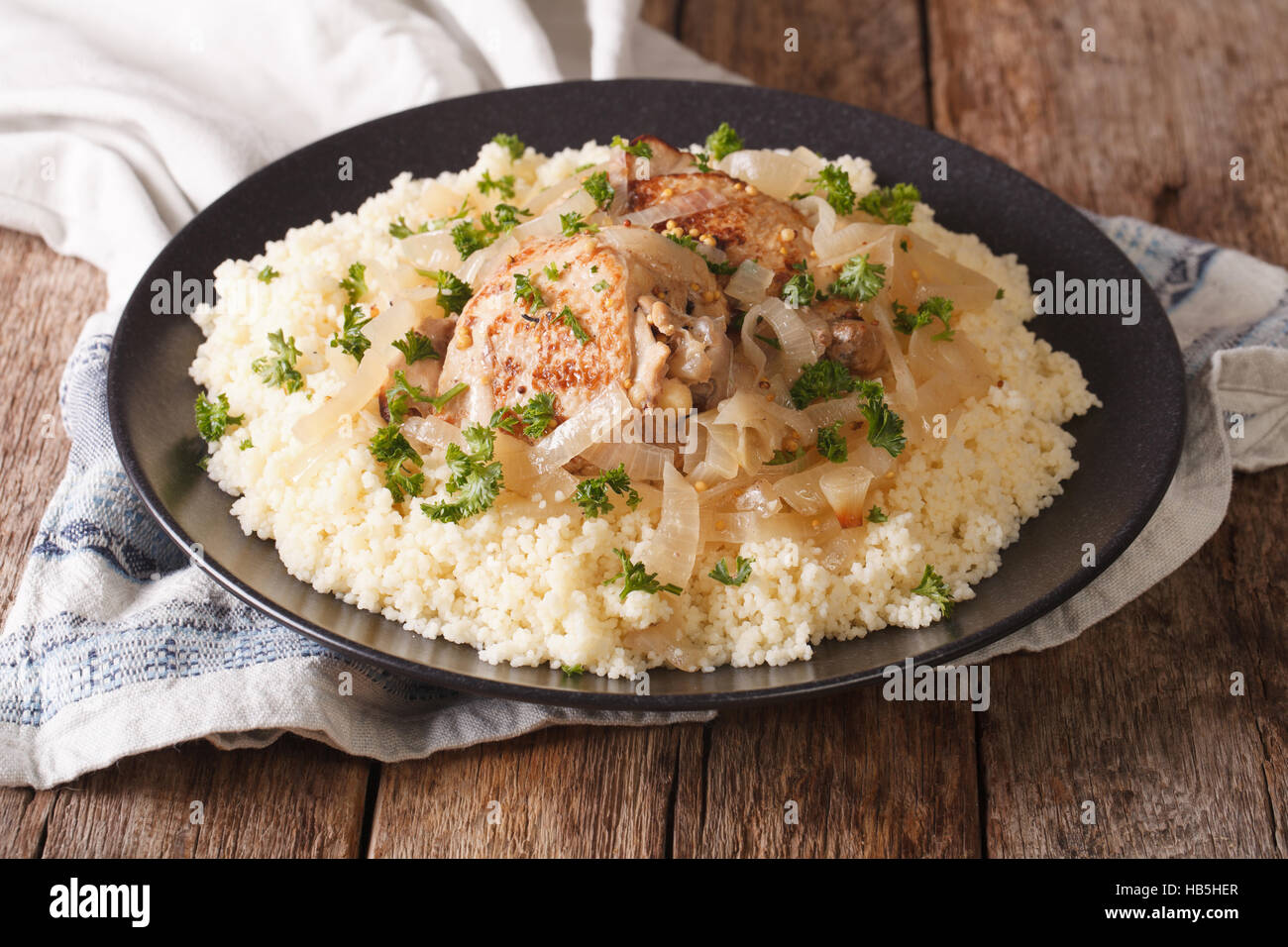 Tasty African food Chicken Yassa with marinated onions and couscous