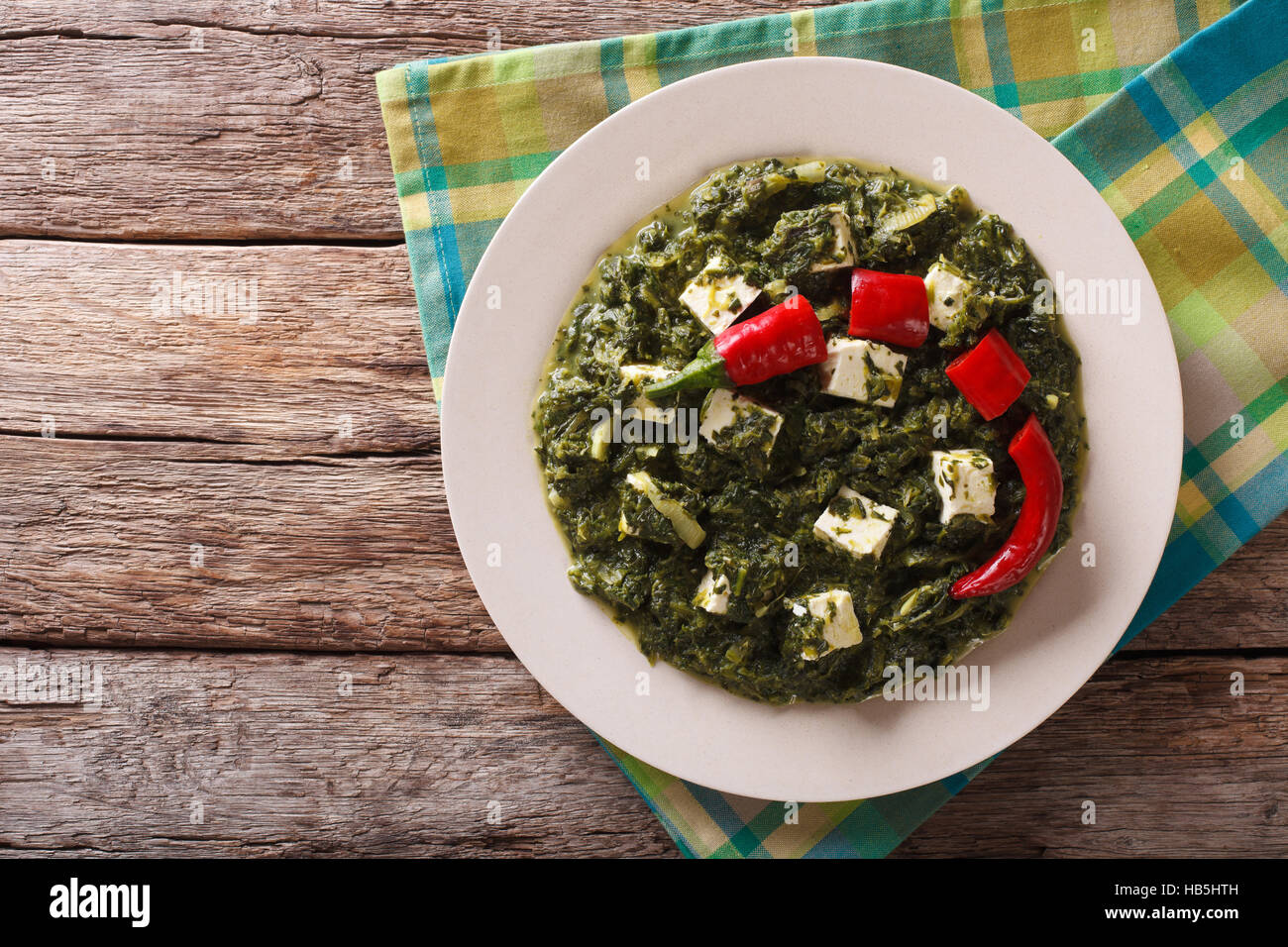 Indian Palak paneer in spicy spinach with cheese closeup on the table