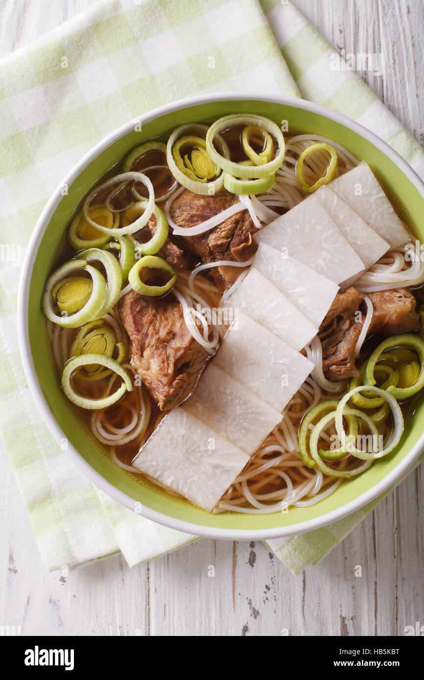 Galbitang Korean soup with beef ribs, rice noodles and daikon close up in a bowl. vertical view from above Stock Photo