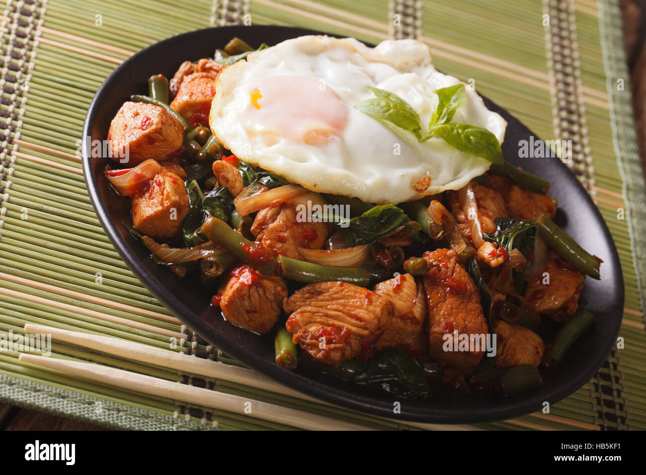 Thai cuisine StirFry Chicken with basil, green beans and a fried egg