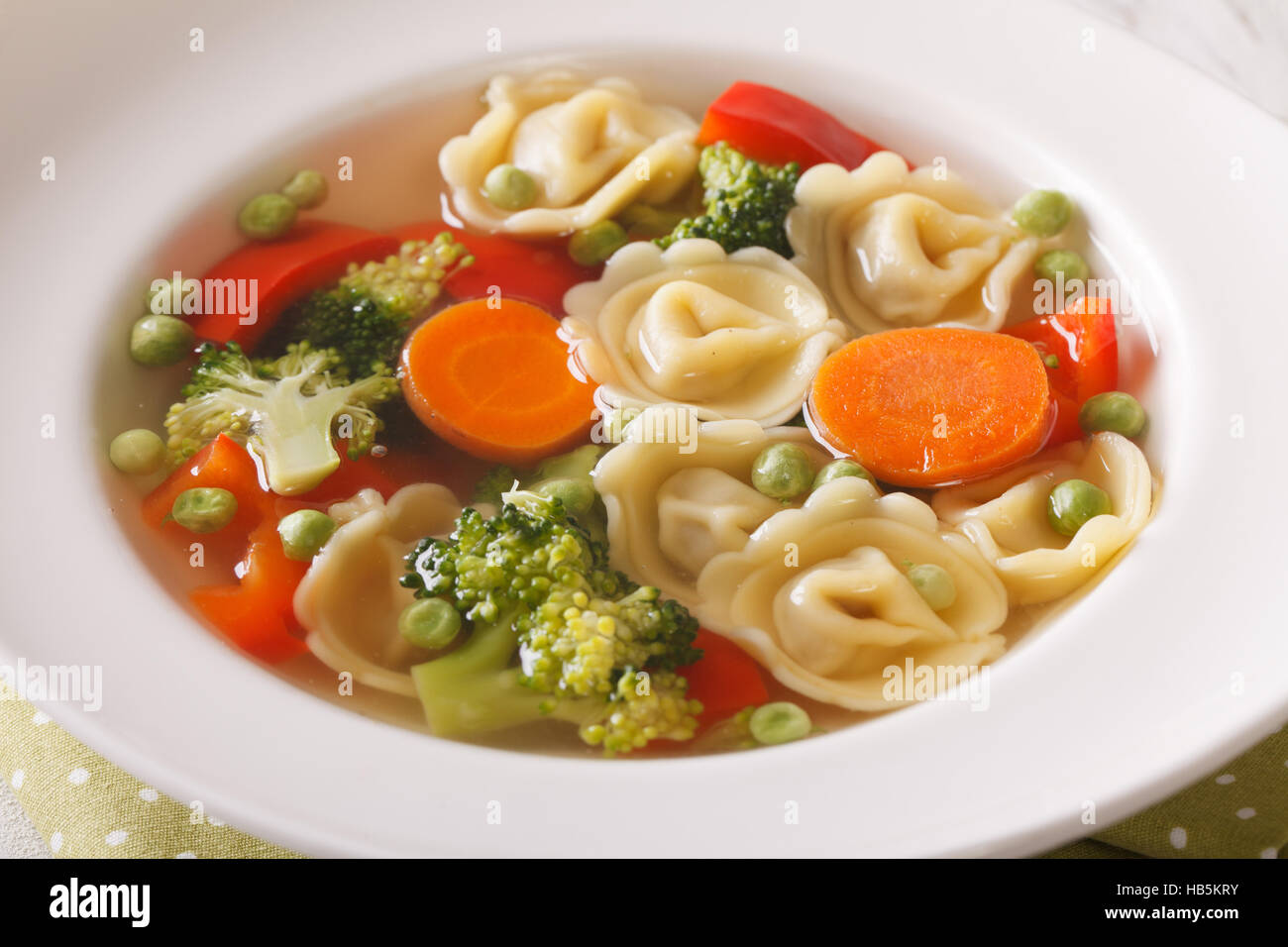 Italian soup with tortellini and vegetables on the plate macro. horizontal Stock Photo Alamy
