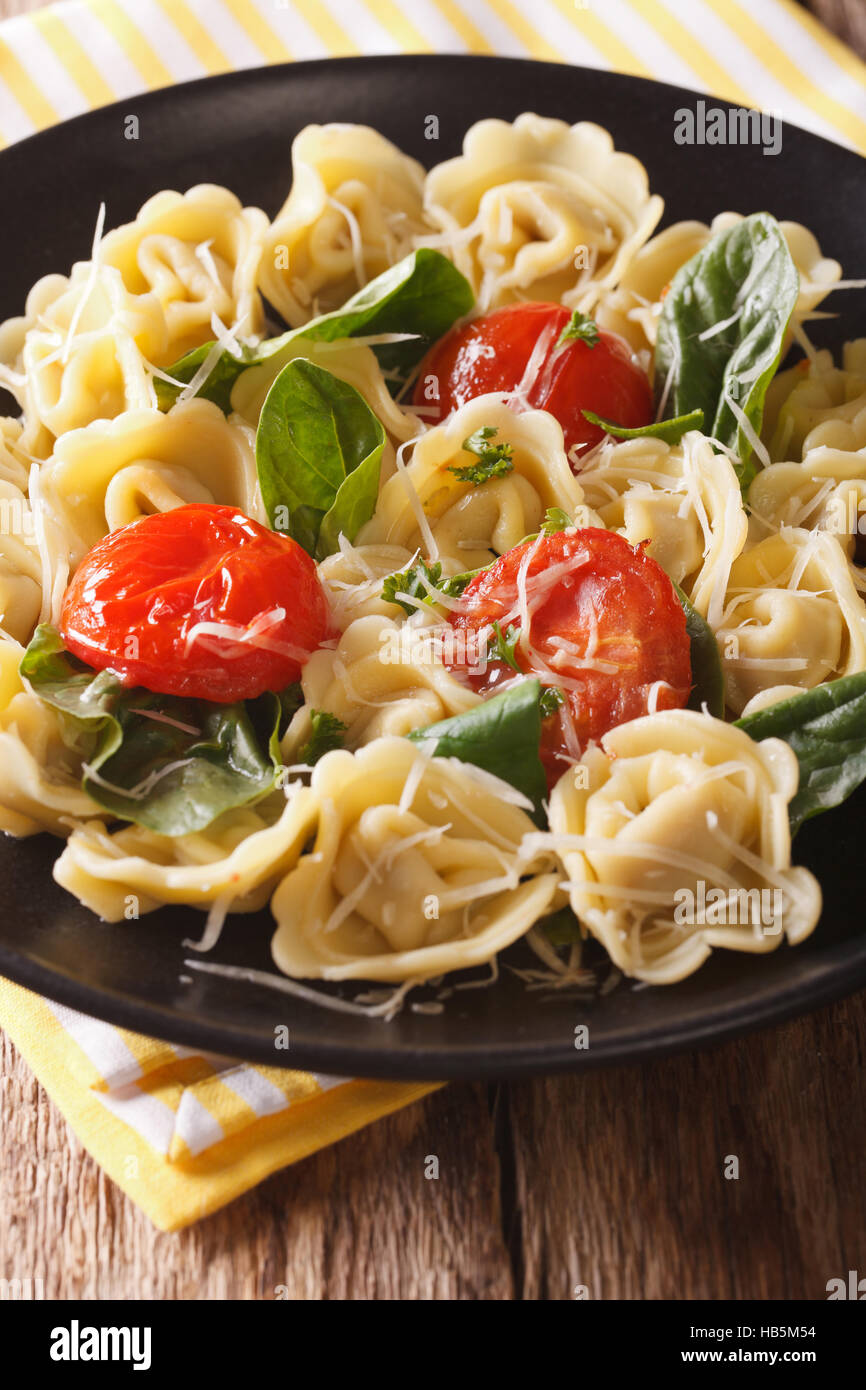 Italian tortellini with spinach and parmesan close-up on a plate. vertical Stock Photo