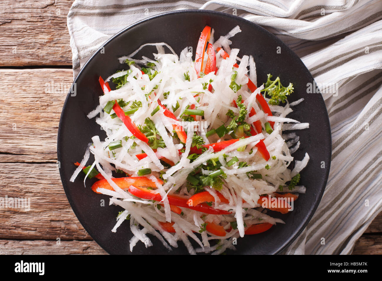 healthy food: salad of daikon with pepper and herbs closeup on a plate. Horizontal view from above Stock Photo