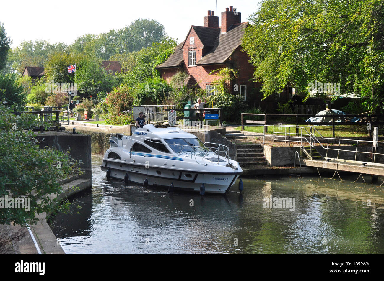 Berkshire - Sonning Lock - river Thames - pleasure cruiser leaving the lock - sunlight and shadows - reflections - cottage Stock Photo