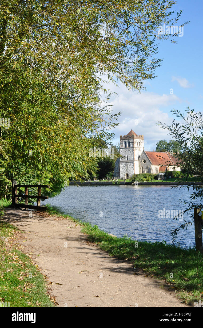 Thames path - portrait view over river to Bisham church in Berkshire - sunlight - blue sky - reflections - trees in summer leaf Stock Photo