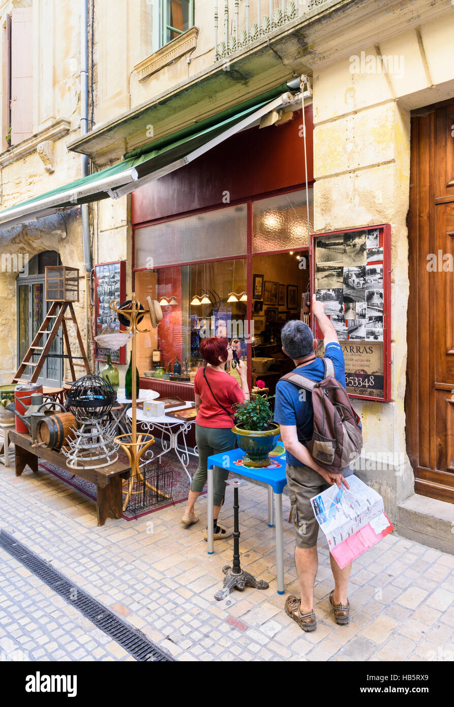 Couple looking at an antique shop in the old medieval town of Sommières, Gard, France Stock Photo