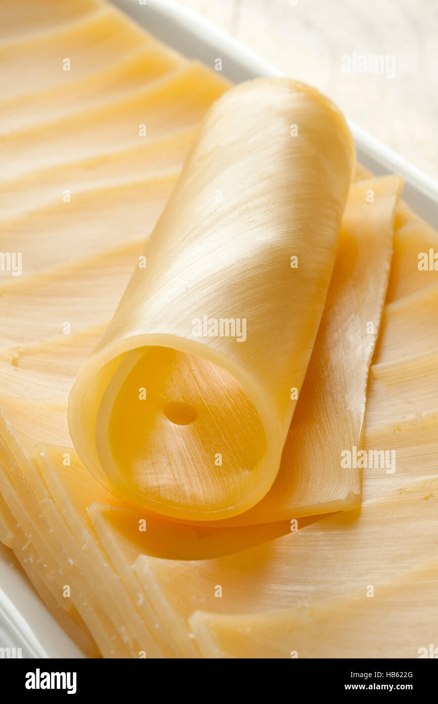 Gouda cheese in slices and a roll Stock Photo